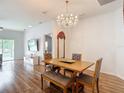 Bright dining area showcases wood floors, modern lighting fixture, and access to the outdoor pool area at 5526 Braddock Dr, Zephyrhills, FL 33541