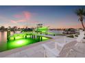 Waterfront property featuring a private boat dock, boat lift, and seating to enjoy the waterfront at 935 Eden Isle Ne Dr, St Petersburg, FL 33704