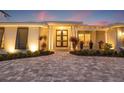 Elegant home exterior showcasing a beautifully landscaped front yard and inviting entrance with double doors at 935 Eden Isle Ne Dr, St Petersburg, FL 33704