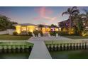 Stunning waterfront home featuring a private dock and inviting outdoor seating area with sunset views at 935 Eden Isle Ne Dr, St Petersburg, FL 33704