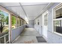 The home's front porch features a wall of windows, a painted floor, and a white entry door at 10130 Burton St, New Port Richey, FL 34654