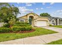 Attractive home with beautiful landscaping, a blue entry door and a two-car garage at 10223 Charleston Corner Rd, Tampa, FL 33635