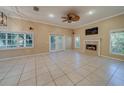 Spacious living room features neutral walls, tile floors, a fireplace, and double doors to the outside at 11386 Churchhill Trl, Seminole, FL 33772