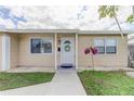 Charming house with a white door, decorative wreath, and lovely flowers, surrounded by a green lawn at 1142 56Th N Ave, St Petersburg, FL 33703