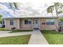 Inviting home featuring a well-kept lawn, tidy landscaping, and a clear walkway to the front entrance at 1142 56Th N Ave, St Petersburg, FL 33703