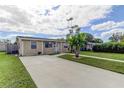 Pleasant home with a spacious driveway and a lush front yard featuring vibrant landscaping and a quaint palm tree at 1142 56Th N Ave, St Petersburg, FL 33703