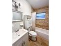 Well-lit bathroom with tile backsplash, a vanity, a toilet, and a shower over tub at 1228 Pineview Ave, Clearwater, FL 33756