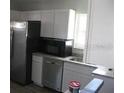 Bright kitchen featuring stainless steel appliances, white cabinets, and stone countertops at 1228 Pineview Ave, Clearwater, FL 33756