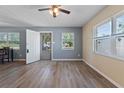 Bright living room with wood-look floors, two windows, and neutral wall paint at 14734 11Th St, Dade City, FL 33523