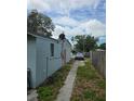 Side view of a single-story house with a walkway, featuring neutral siding and a well-defined roofline at 1607 Stevensons Dr, Clearwater, FL 33755