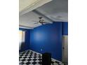 Room with black and white floors, bold blue wall, and ceiling fan at 1607 Stevensons Dr, Clearwater, FL 33755
