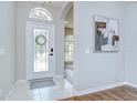 Bright entryway featuring a decorative glass door and neutral tile flooring, and an arched entry to other rooms at 16501 Sandhill Crane Dr, Spring Hill, FL 34610