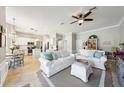 Open-concept living area with white sofas, a ceiling fan, tile flooring, and an eat-in kitchen at 17712 Long Ridge Rd, Tampa, FL 33647