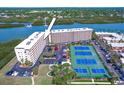 Aerial view of complex showing the pool, tennis courts, parking, boat docks and water access at 19451 Gulf Blvd # 506, Indian Shores, FL 33785