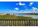 Scenic water view from the balcony on a bright day with beautiful green trees at 19451 Gulf Blvd # 506, Indian Shores, FL 33785