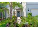 Inviting front entrance with lush landscaping leading to a covered porch and seating at 20472 Monza Loop, Land O Lakes, FL 34638