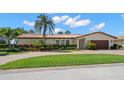 Charming one-story home featuring a red tile roof, manicured landscaping, and a brick driveway at 2057 Kansas Ne Ave, St Petersburg, FL 33703
