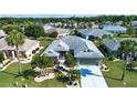 Expansive aerial view of a beautiful house with mature landscaping and a perfectly maintained lawn in a quiet neighborhood at 2217 W Del Webb Blvd, Sun City Center, FL 33573