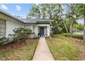 Inviting front entrance with a well-maintained walkway and lush landscaping at 235 Woodridge Cir, Oldsmar, FL 34677