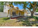 Attractive home featuring a charming porch, a two-car garage, and a nicely landscaped front yard with mulch at 24231 Satinwood Ct, Lutz, FL 33559