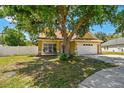 Inviting home features a cozy front porch, a two-car garage, and a lush front lawn at 24231 Satinwood Ct, Lutz, FL 33559