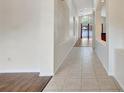 Bright hallway featuring tile flooring and archways, leading to a living area with wood floors at 3510 Hickory Hammock Loop, Wesley Chapel, FL 33544