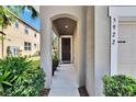 Inviting entryway with arched doorway, manicured plants, and clearly displayed house number at 5922 Grand Sonata Ave, Lutz, FL 33558