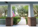 Inviting front porch view framed by brick pillars, green landscaping, and a clear walkway leading to the home at 6015 Shell Ridge Dr, Lithia, FL 33547