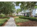 Serene walkway leading to a charming home with a welcoming front porch, surrounded by lush landscaping at 6015 Shell Ridge Dr, Lithia, FL 33547