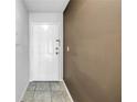 Entryway with neutral paint, gray tile flooring, and a white front door at 650 Island Way # 204, Clearwater Beach, FL 33767