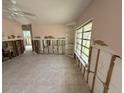 View of the living room featuring tile floors, a ceiling fan, and a window at 6706 Del Prado Ter, New Port Richey, FL 34652