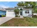 Charming single-Gathering home featuring a garage and well-maintained front yard, perfect for curb appeal at 8605 N Taliaferro Ave, Tampa, FL 33604