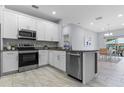 Modern kitchen featuring stainless steel appliances, granite countertops, and white cabinetry at 8605 N Taliaferro Ave, Tampa, FL 33604