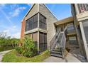 Condo exterior shows stairs to the front door, with mature landscaping and water view at 9100 Dr Martin Luther King Jr N St # 314, St Petersburg, FL 33702