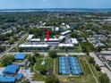 Aerial view of a condo community featuring tennis courts, lakes and landscaping at 948 Virginia St # 202, Dunedin, FL 34698