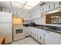 Kitchen featuring white appliances, white cabinets with unique handles and marble tile flooring at 948 Virginia St # 202, Dunedin, FL 34698