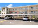 Exterior of condo building with covered parking area and several parked vehicles at 948 Virginia St # 202, Dunedin, FL 34698
