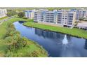 Wide aerial view showcasing condos and surrounding lake with fountain, green spaces, and parking at 960 Starkey Rd # 7202, Largo, FL 33771