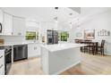 Modern kitchen featuring an island with white countertop and stainless steel appliances with an adjacent dining area at 1047 Deer Hollow Way, Sarasota, FL 34232
