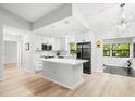 Bright, airy kitchen with white cabinetry, stainless steel appliances and a large island at 1047 Deer Hollow Way, Sarasota, FL 34232