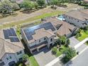 Aerial view of a home with solar panels, tile roof, pool, and well-manicured backyard at 11227 Hawks Fern Dr, Riverview, FL 33569