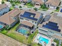 An aerial view of a home with solar panels, a pool, and a screened-in patio at 11227 Hawks Fern Dr, Riverview, FL 33569