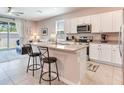 Bright kitchen featuring white cabinets, stainless appliances, and a granite-topped island with bar seating at 2882 Suncoast Plains Dr, Odessa, FL 33556