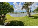 Serene backyard view overlooking a calm lake, framed by lush greenery and trees at 3890 Mainlands N Blvd, Pinellas Park, FL 33782