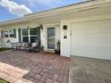 Inviting front entrance with brick patio, seating, and attached garage at 3890 Mainlands N Blvd, Pinellas Park, FL 33782