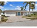 Attractive single-Gathering home boasts a brick driveway, attached garage, and vibrant blue front door at 3910 Doral Dr, Tampa, FL 33634