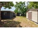 Expansive backyard featuring multiple storage sheds and mature trees, offering plenty of outdoor space at 4311 W Oklahoma Ave, Tampa, FL 33616