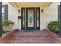 Front porch featuring a black door with decorative glass, brick steps, and black sconces at 4410 19Th N St, St Petersburg, FL 33714