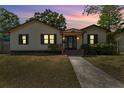 Charming single Gathering home with tan siding, black shutters, and a walkway at twilight at 4410 19Th N St, St Petersburg, FL 33714
