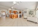 Open-concept living area featuring a fireplace, tiled floors, ceiling fans, and lots of natural light at 4490 38Th S Way, St Petersburg, FL 33711